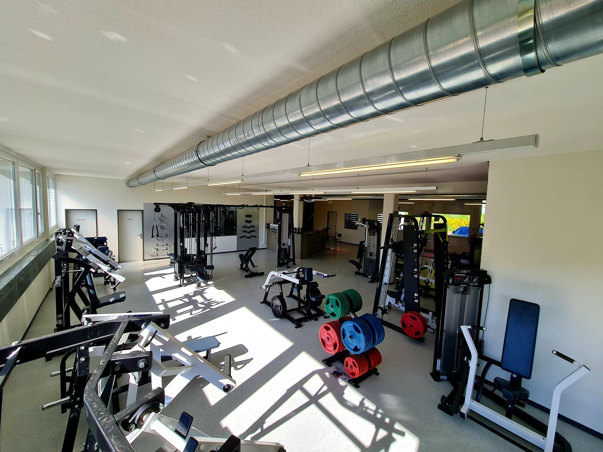 Helle Trainingshalle mit Geräten